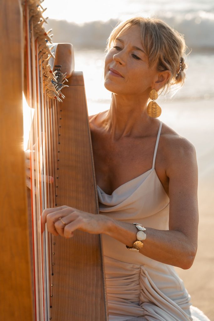 Danielle Riegel playing the harp by the ocean